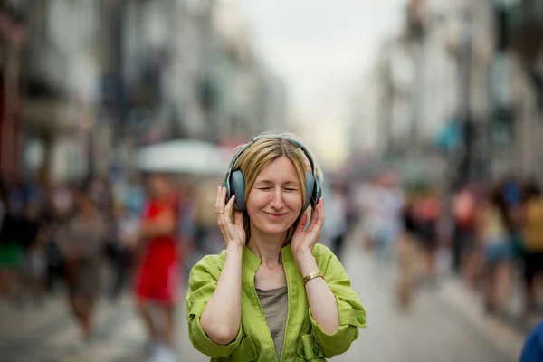 Kobieta Nosząca Słuchawki Zatłoczonej Ulicy — Zdjęcie stockowe