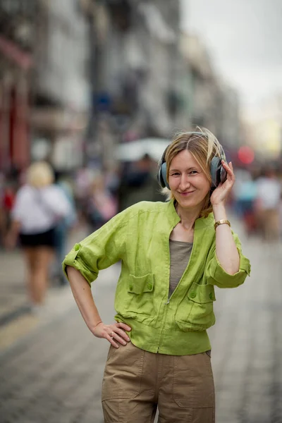 Una Mujer Disfruta Música Los Auriculares Mientras Está Pie Una —  Fotos de Stock