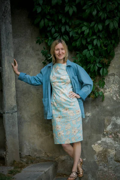 Μια Γυναίκα Ένα Καλοκαιρινό Φόρεμα Στέκεται Κοντά Έναν Τοίχο Πρασίνου — Φωτογραφία Αρχείου