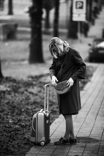 街上一个手里拿着手提箱的女人 检查她的钱包 黑白照片 — 图库照片