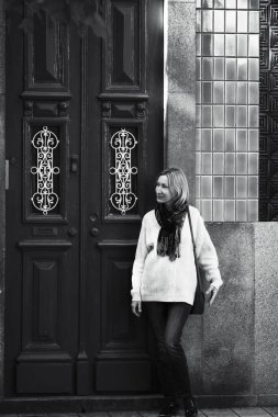 Portekiz 'deki bir apartmanın kapısında bir kadın. Siyah beyaz fotoğraf.