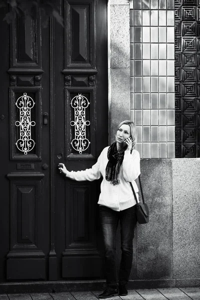 一名妇女在葡萄牙一幢公寓楼门口用手机交谈 黑白照片 — 图库照片