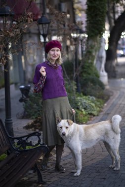 Sokakta başıboş bir köpekle duran bir kadın.. 