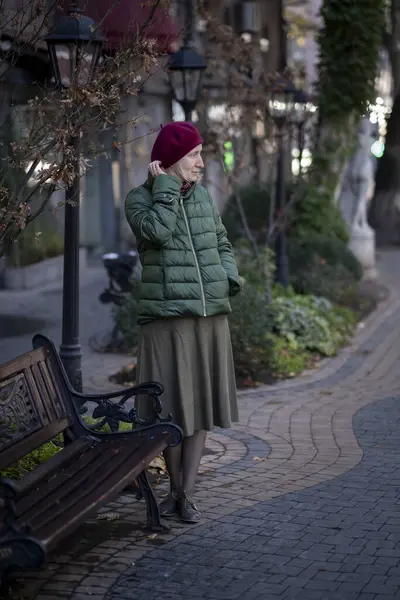 Parktaki bankın yanında sonbahar kıyafetleri içinde bir kadın.. 