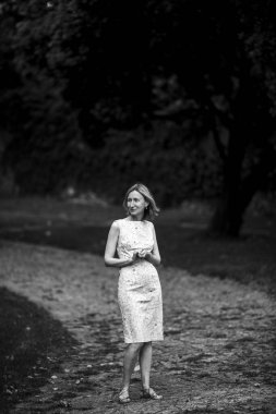 Parkta çakıl yolunda bir kadın. Siyah beyaz fotoğraf.