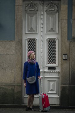Ön kapıda kırmızı valizli bir kadın duruyor, Porto, Portekiz..