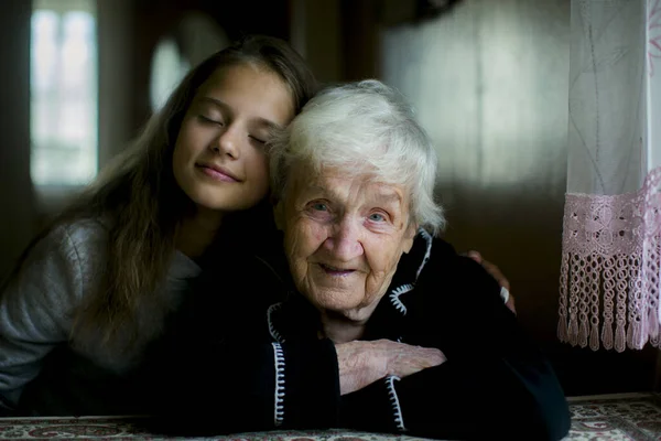 小さな女の子は優しく彼女を訪問するとき彼女の曾祖母を抱きしめます — ストック写真