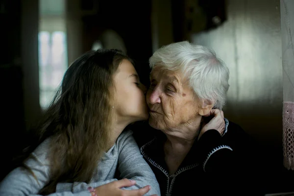 女の子は彼女を訪問しながら彼女の偉大な祖母にキス ロイヤリティフリーのストック画像