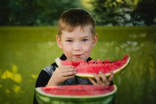 Een Jongetje Eet Een Watermeloen Stockfoto