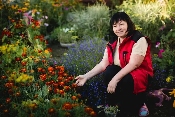 Eine Frau Posiert Ihrem Blumengarten Stockfoto