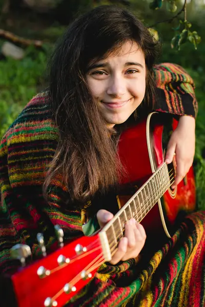 Ein Mädchen Das Gitarre Spielt Sitzt Sommergarten lizenzfreie Stockbilder