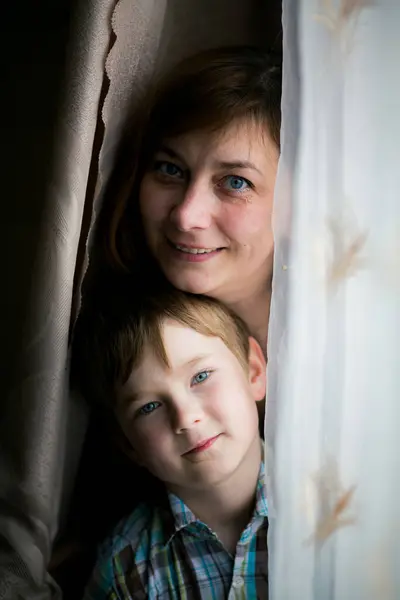 一个女人和她年幼的儿子在房间里玩耍的画像 图库图片