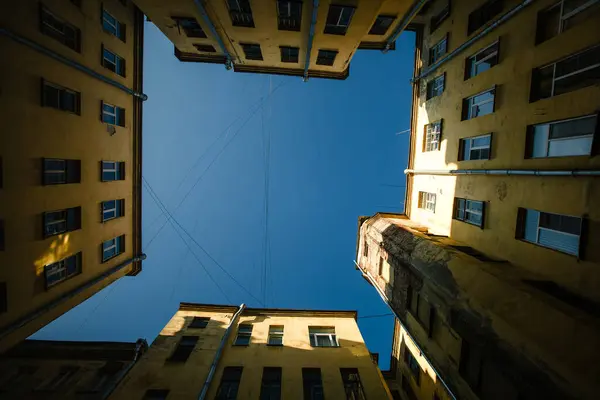 페테르부르크 안뜰에서 고요한 분위기 건물에 둘러싸인 활기찬 하늘은 평화와 매력의 스톡 이미지