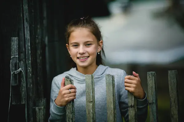 Ein Mädchen Teenageralter Steht Hinter Einem Holzzaun Ihr Blick Richtet lizenzfreie Stockbilder