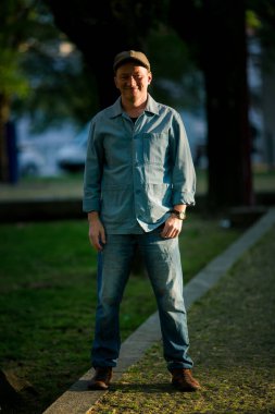 Parktaki orta yaşlı bir adamın portresi, doğanın sükuneti içindeki kendine güvenini yansıtıyor..