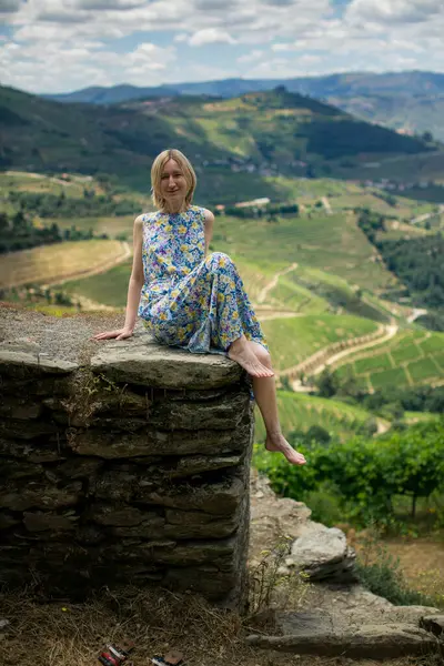 stock image A middle-aged woman enjoys a wine tour in the scenic vineyards of the Douro Valley, Portugal,.