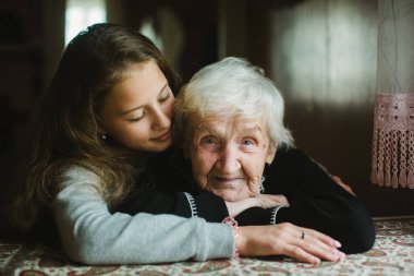 Yaşlı bir kadının portresi. Küçük torunuyla birlikte evlerinin rahatlığında..