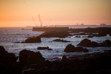 Matosinhos 'un kayalık kıyıları çarpıcı bir günbatımında yıkandı. Portekiz.