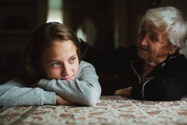 Yaşlı bir kadın ağlayan torununu teselli eder..