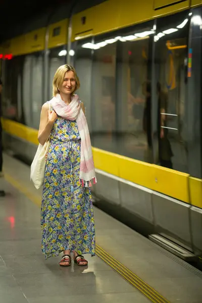 stock image A woman stands in the subway, waiting for the metro.