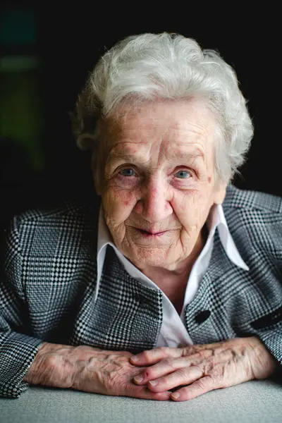 stock image A portrait of an elderly woman with kind eyes and a positive expression, dressed in a business suit.