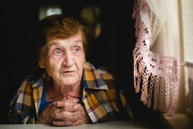 Masada oturan yaşlı bir kadının dokunaklı portresi..