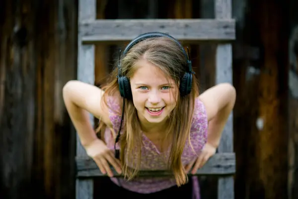 stock image A playful portrait of a teenage girl wearing headphones, with a mischievous smile.