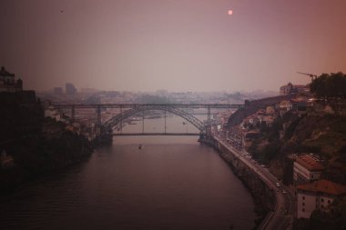 Douro Nehri ve I. Dom Luis Köprüsü, sislerin arasından güneş turuncu renkte parlarken, büyük yangınlardan dolayı yoğun dumanlarla kaplanmıştı..