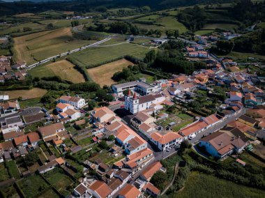Ribeira Grande, Azores 'de kıyı kasabası Maia' nın tepeden aşağı manzarası, dalgalı yeşil tepeler ve engebeli kıyı şeridi boyunca parlayan okyanus dalgaları..