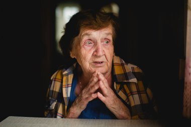 Evinde duygusal olarak yaşlı bir kadının dokunaklı portresi. Yüzü derin bir ifade ve sıcaklıkla dolu..