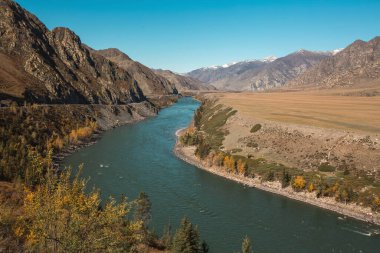 Altai Cumhuriyeti 'ndeki engebeli, kayalık dağların arasından akan bir nehir sert ama çarpıcı doğal manzarayı gözler önüne seriyor..