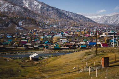 Sonbaharda Altai Cumhuriyeti 'nin dağlarında bir yerleşim köyü, çatıları ve manzarayı kaplayan buzlar, renkli manzaraya taze bir dinginlik katıyor..