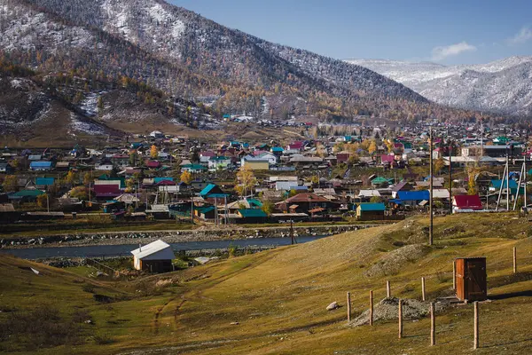 Sonbaharda Altai Cumhuriyeti 'nin dağlarında bir yerleşim köyü, çatıları ve manzarayı kaplayan buzlar, renkli manzaraya taze bir dinginlik katıyor..