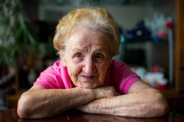 Yaşlı bir kadının yakın plan portresi. Gözleri açık, yorgun ve bilge bir odak noktası. Yüzündeki her kırışıklık zamanı, sessizliği ve anlatılmamış hikayeleri anlatıyor..