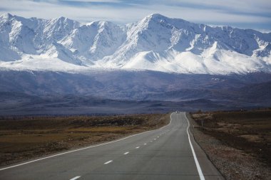 Altai Cumhuriyeti 'ndeki Kuzey Chuya Dağları' na uzanan ıssız bir yol yüksek tepeleri kaplayan devasa kar tarlalarına doğru kayboluyor. Manzara uçsuz bucaksız, soğuk ve görkemli.