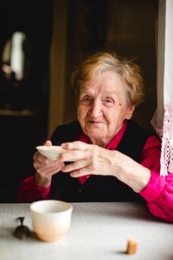 Evde çay içen yaşlı bir kadının portresi. Yüzü sakin ve sıcak. Basitliği, rahatlığı ve günlük hayatın sessiz güzelliğini yakaladığı an..