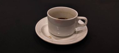 Siyah arka planda fincan tabağı olan siyah kahve lekeli beyaz fincan..