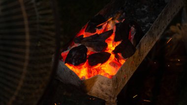 Izgara et için şöminede kömür yakmak ve elektrikli vantilatörle yelpaze kullanmak. Izgara yemek için odun kömürü.