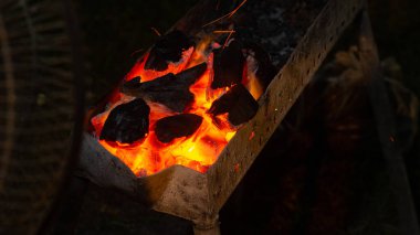 Izgara et için şöminede kömür yakmak ve elektrikli vantilatörle yelpaze kullanmak. Izgara yemek için odun kömürü.