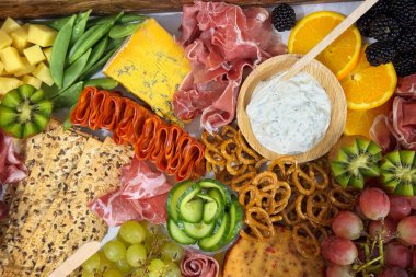 Çimenlikte meyve, kraker, et ve peynir 