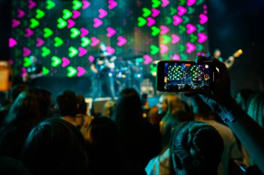 Hands with phones on concert, atmosphere on concert, stage lights clipart