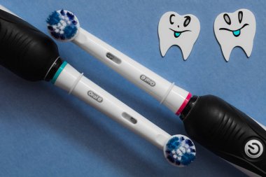 Frankfurt, Almanya - 1 Mayıs 2021: İki Elektrikli diş fırçası Oral-B Cross Action PRO 750 siyah baskı mavi arka planda