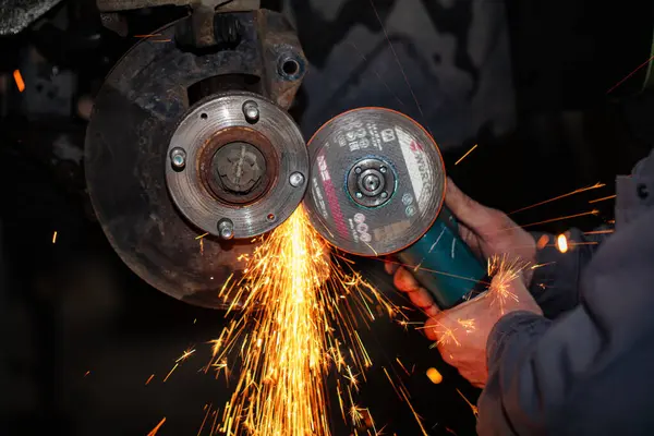 automobile wheel repair using angle grinder in car service