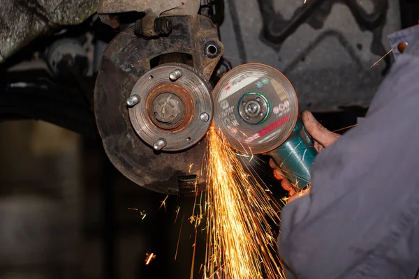 automobile wheel repair using angle grinder in car service