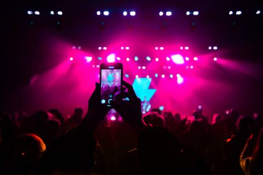 Konserde telefonlu eller, konserde atmosfer, sahne ışıkları