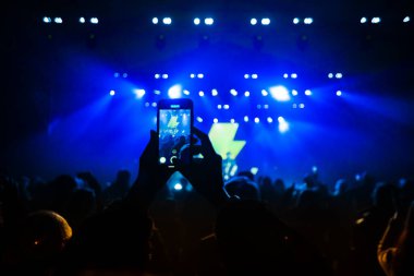 Hands with phones on concert, atmosphere on concert, stage lights