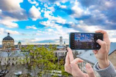 Akıllı telefon tutan ve Lviv, Ukrayna 'da fotoğraf çeken kadın eller.