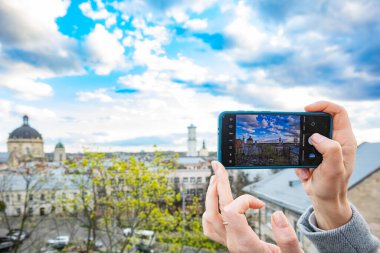 Akıllı telefon tutan ve Lviv, Ukrayna 'da fotoğraf çeken kadın eller.