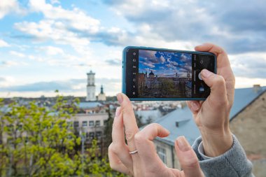 Akıllı telefon tutan ve Lviv, Ukrayna 'da fotoğraf çeken kadın eller.