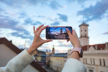 Akıllı telefon tutan ve Lviv, Ukrayna 'da fotoğraf çeken kadın eller.